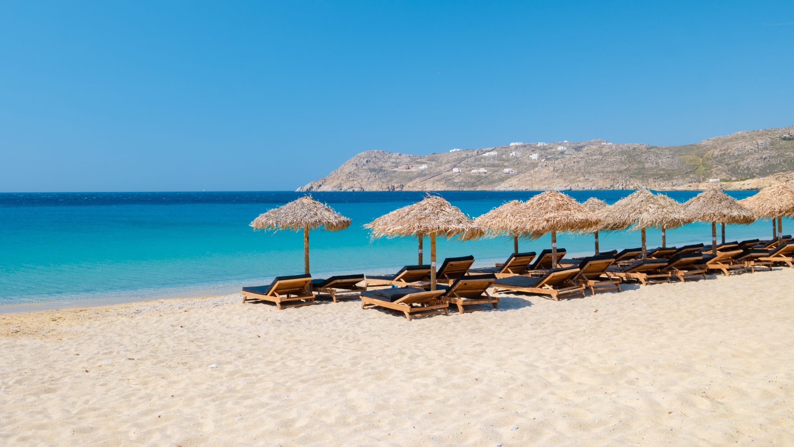 Mykonos,Beach,During,Summer,With,Umbrella,And,Luxury,Beach,Chairs
